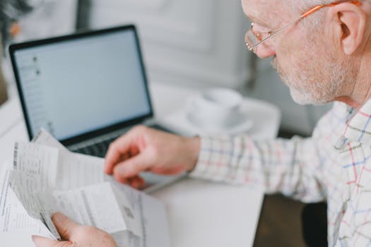 man holding a calculator and looking at financial documents