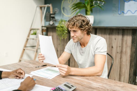 person holding a calculator and mortgage papers